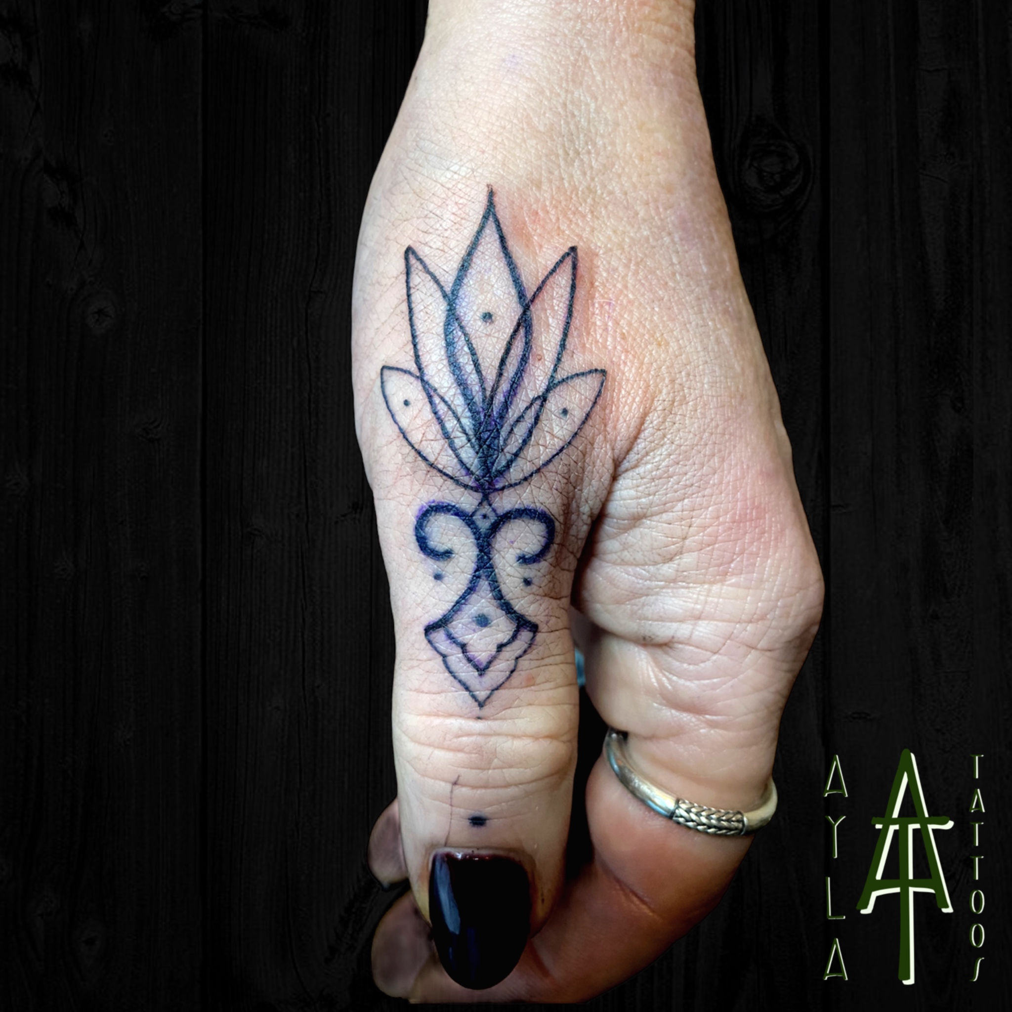 Ornamental thumb tattoo